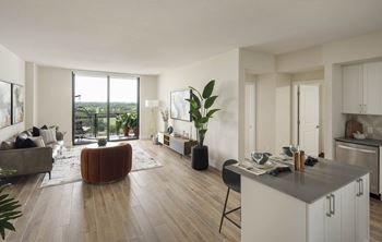 A modern living room with a large window and a kitchen area.